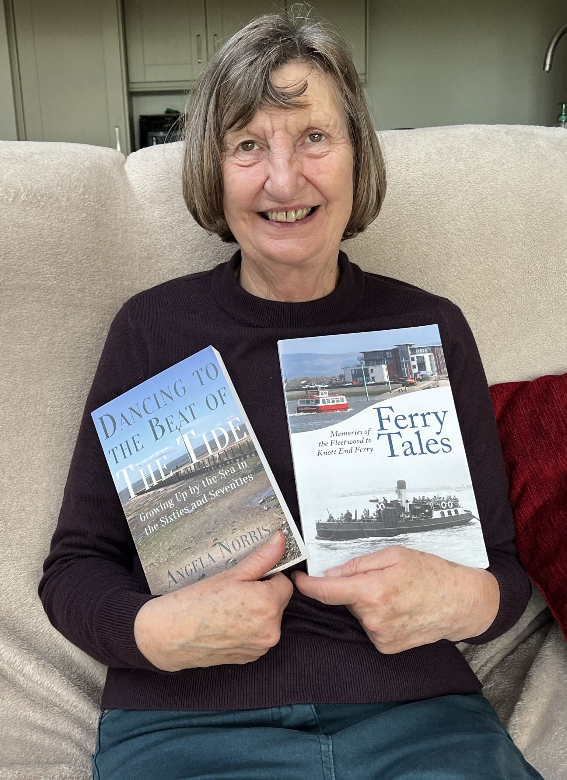 Angela Norris sitting with her books